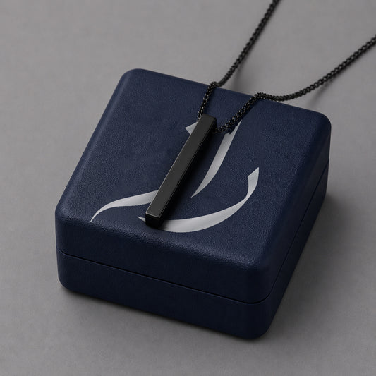 Black pendant over a dark blue jewelry box with a grey background