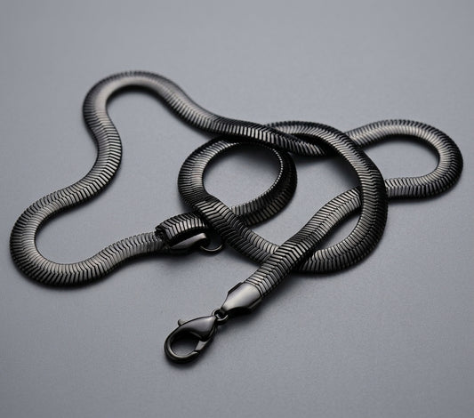 Black snake chian with a metal clasp on a grey background