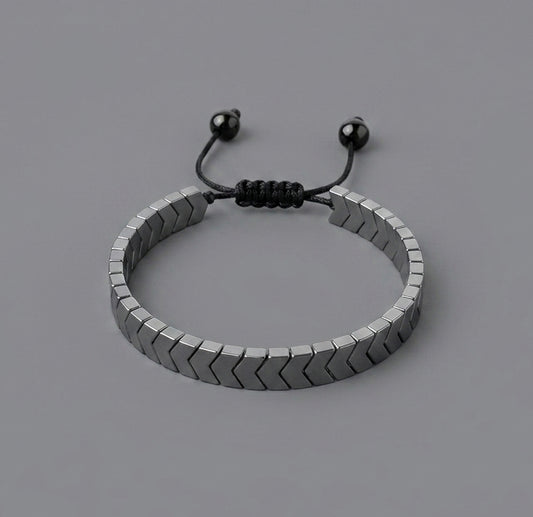 Bracelet with metal arrows linked on a grey background