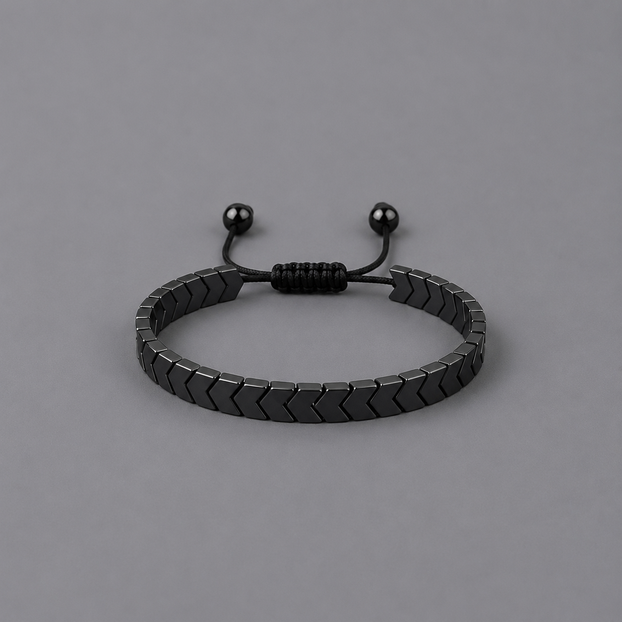 Black bracelet with arrow design on a grey background