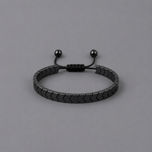 Black bracelet with arrow design on a grey background
