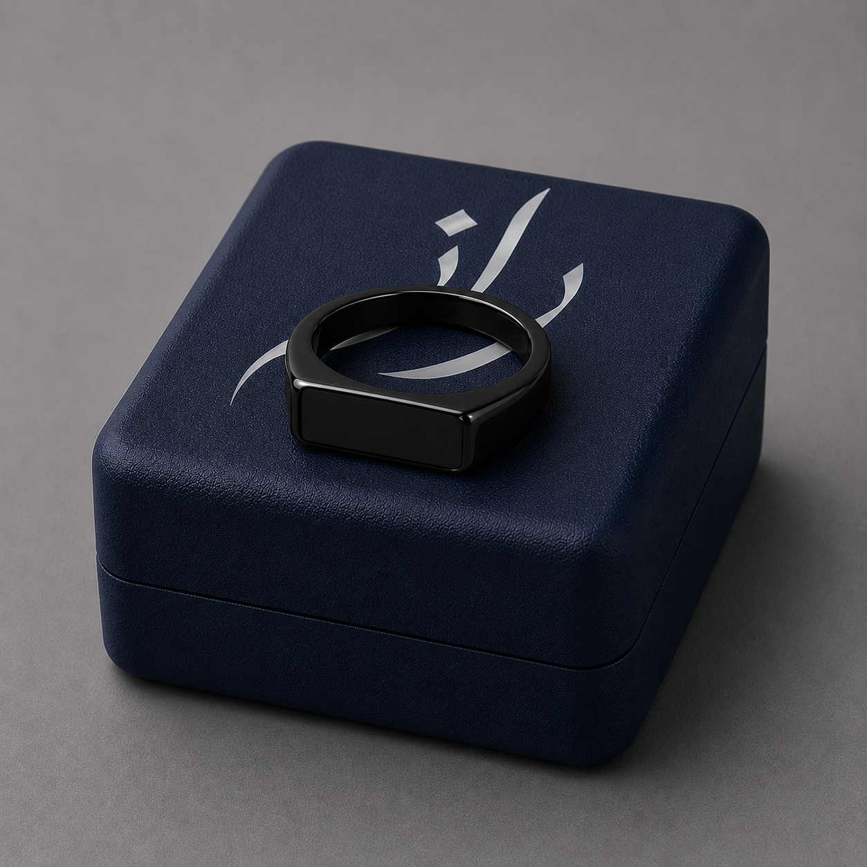 Black ring on a navy blue jewelry box  on a grey background