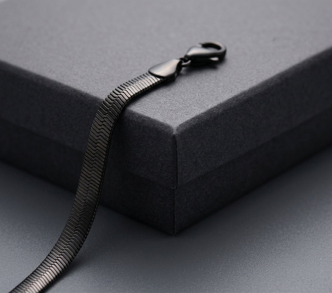 Black snake chain on a grey surface