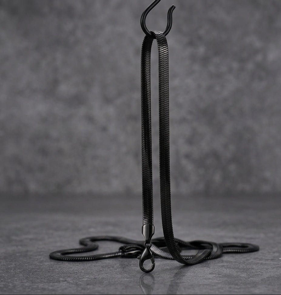 Black snake chain hanging on hook on a grey background