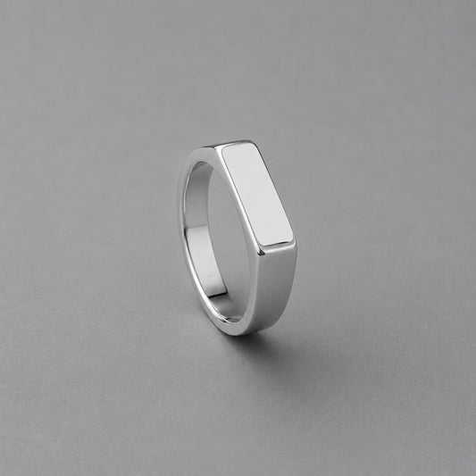 Silver ring with a flat top on a grey background