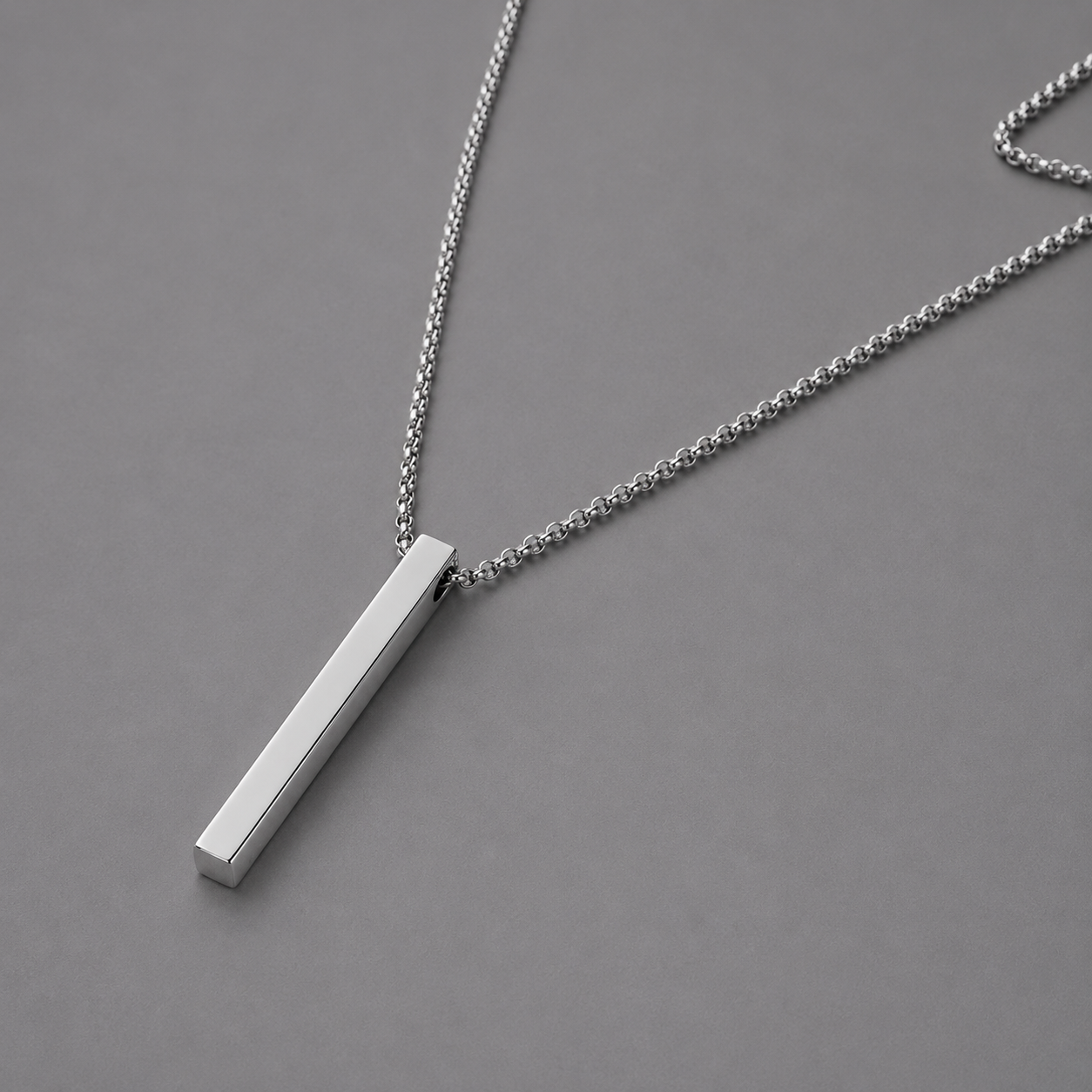 Silver necklace with a rectangular pendant on a grey background